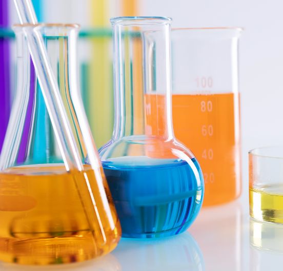 //www.kalpsutra.com/wp-content/uploads/2023/12/closeup-shot-different-flasks-with-colorful-liquids-white-surface-lab.jpg